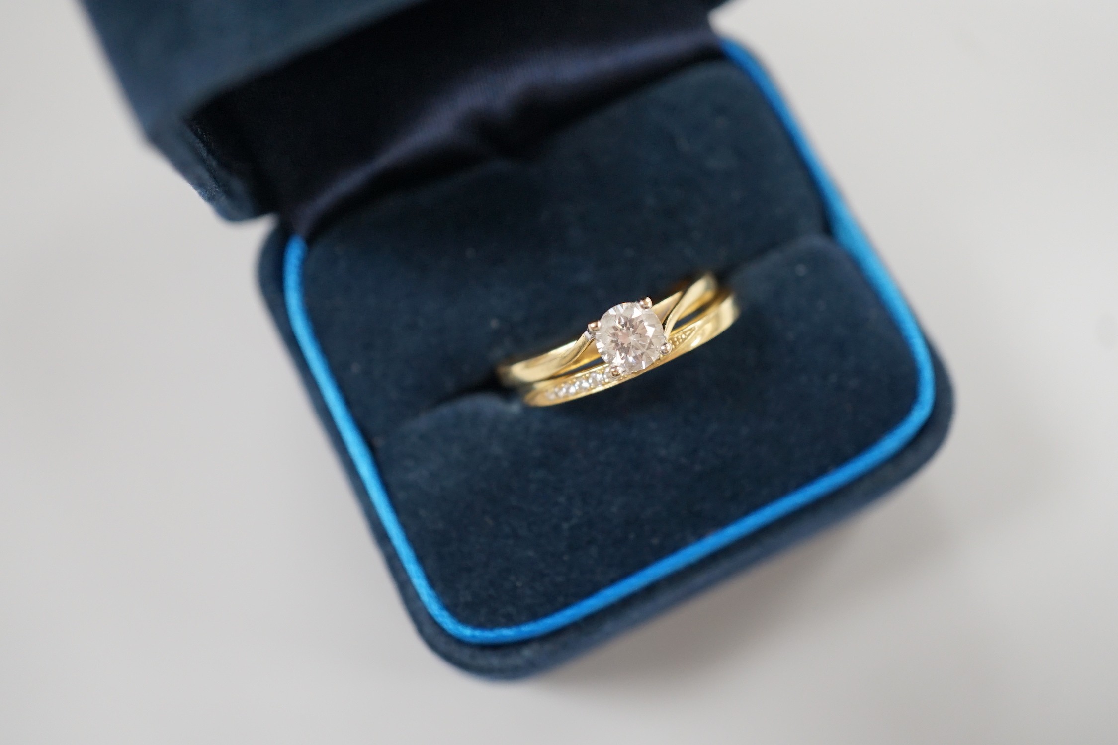 A modern Parkhouse 18ct gold wedding set, comprising a graduated ten stone diamond chip set half hoop band and an Isabella solitaire diamond ring, the latter with accompanying GIA report dated 4/12/2014, stating the ston